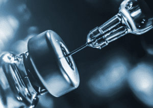 Detail of a syringe needle in a vial