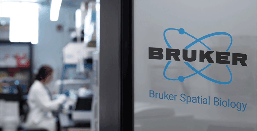 Person working in a lab behind door labeled "Bruker Spatial Biology"